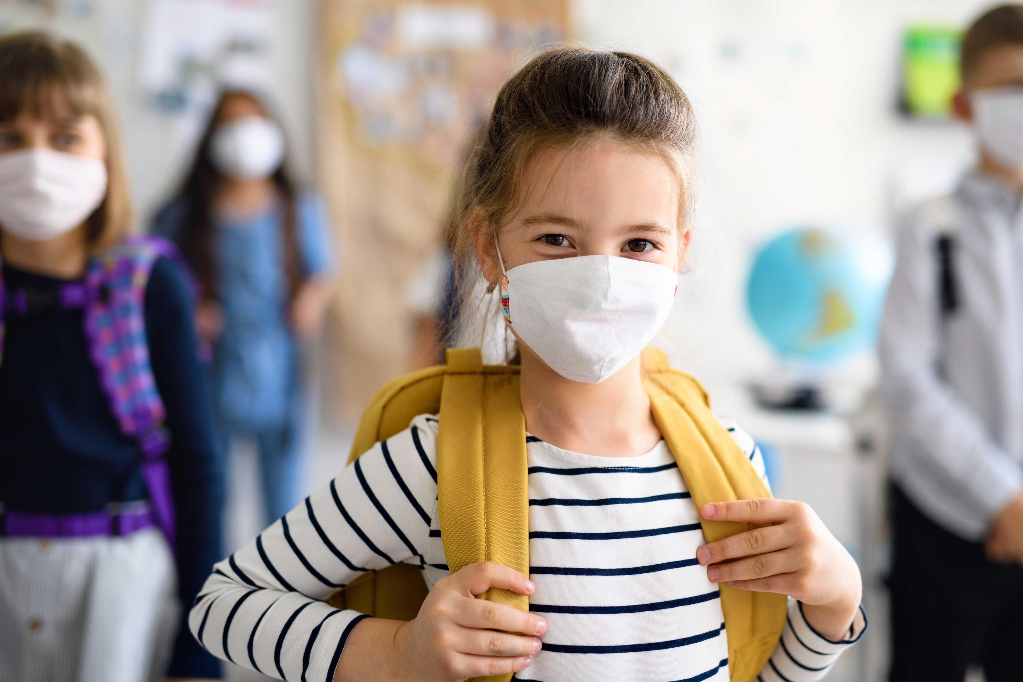 Élève d'école élémentaire avec un masque et son sac à dos